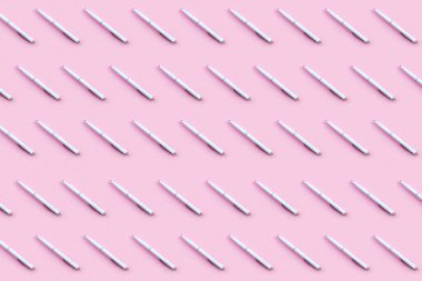 Pembe kâğıt arka planda güzel beyaz bir kalem. Üst görünüm, düz görünüm, boşluk konseptini kopyala.