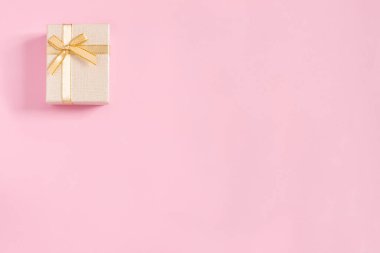Pembe kağıt arka planda tebrik etmek için altın hediye kutuları. Üst görünüm, düz görünüm, boşluk konseptini kopyala.