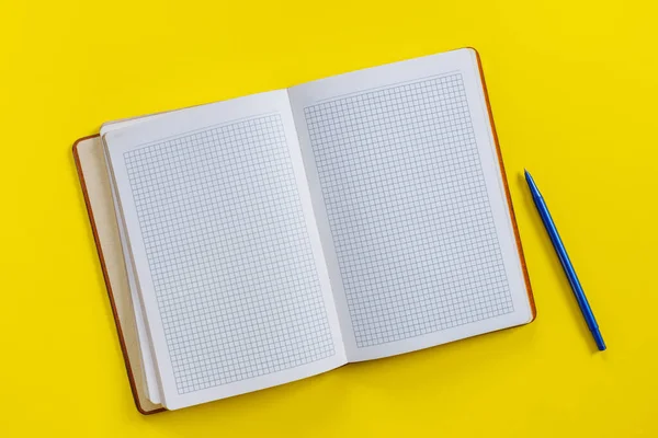 Zineのスタイルでテキスト黄色の背景のためのペンで空のノートブックを開きます トップ表示フラットレイコピースペース — ストック写真