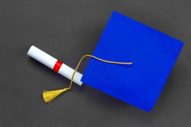 Mezuniyet şapkası ve siyah kağıt üzerine diploma. Uzaktan eğitim mezuniyeti