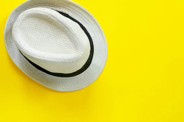 黄色の紙の背景にファッショナブルなわらの白い帽子 — ストック写真