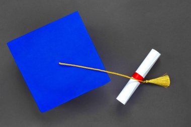 Mezuniyet şapkası ve siyah kağıt üzerine diploma. Uzaktan eğitim mezuniyeti