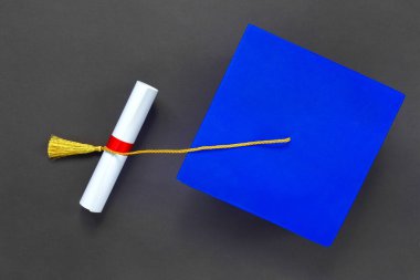 Mezuniyet şapkası ve siyah kağıt üzerine diploma. Uzaktan eğitim mezuniyeti