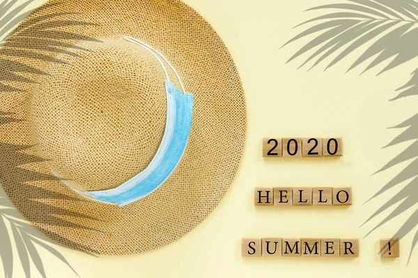 藁帽子と青い医療用マスクと紙ベージュの背景 コンセプトテキスト デザインのための Hello Summer 2020 — ストック写真