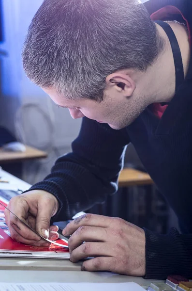 Young man in the process of offset printing and color correction