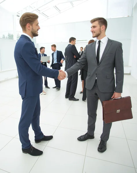 Dos hombres de negocios guapos haciendo apretón de manos en una oficina —  Fotos de Stock