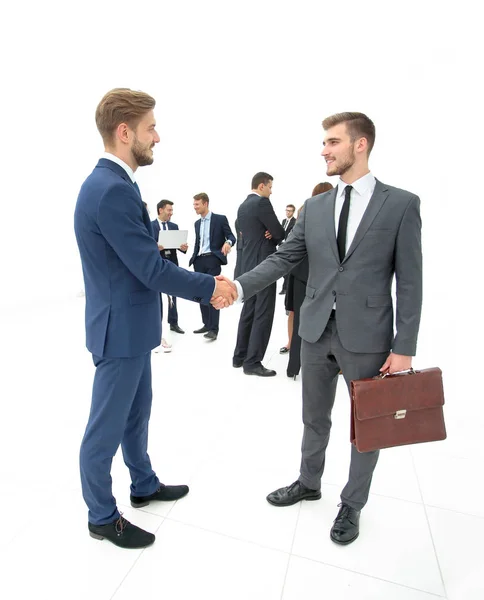 Zwei Geschäftsleute einigen sich, ihre Kollegen stehen in der Nähe — Stockfoto