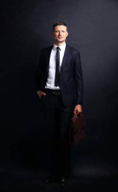 koyu arka plan üzerinde yakışıklı kendine güvenen işadamı