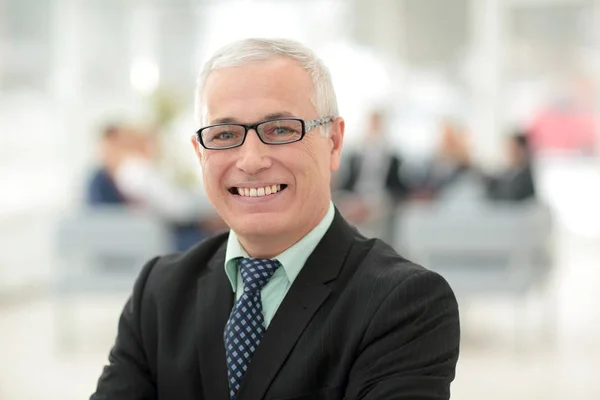 Mature amical homme d'affaires aux cheveux blancs dans un bureau moderne — Photo