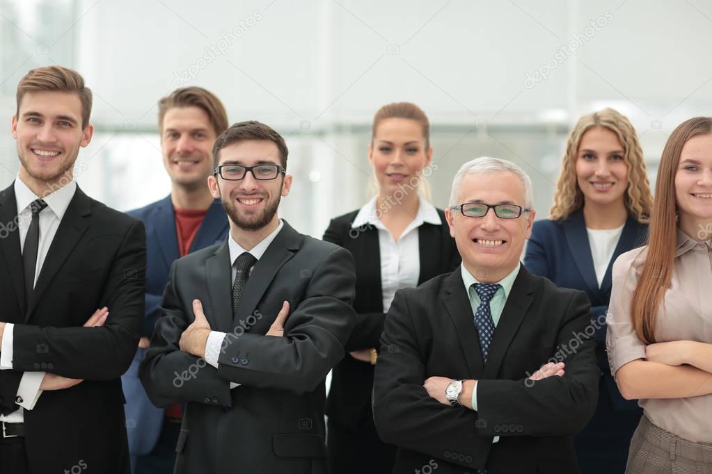 Mature businessman and cheerful business team on office backgrou