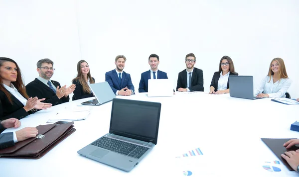 Vue latérale de l'équipe d'affaires de Smilimg, assis à une table ronde sur — Photo