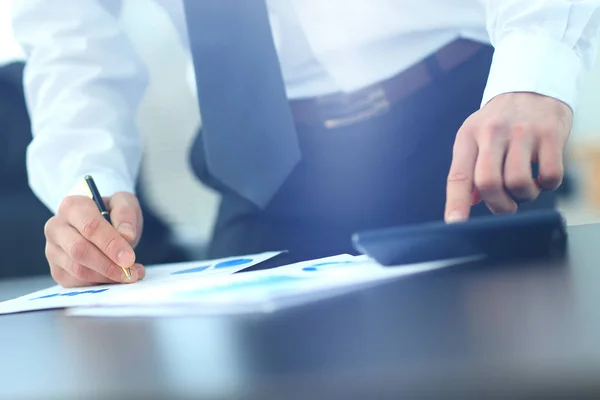 Affärsman med kalkylatorn i office — Stockfoto