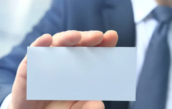 Mans hand showing business card - close seup shot on grey background — стоковое фото