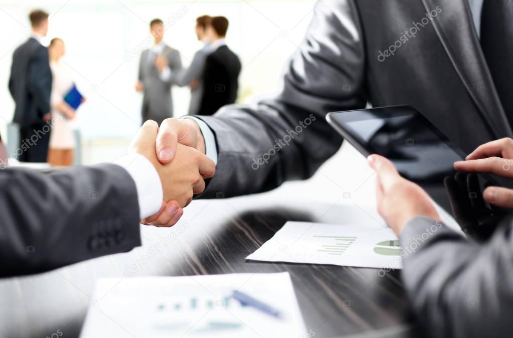 handshake of business partners after discussion of the financial