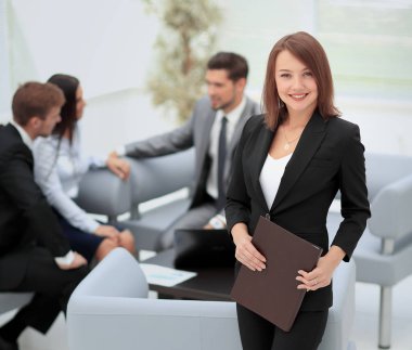 Başarılı bir iş kadını arkasında personeliyle duruyor.