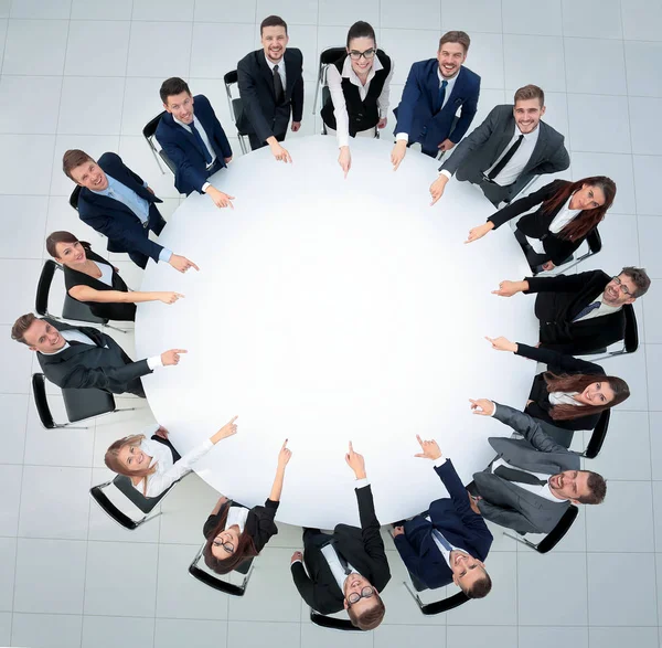 Equipo empresarial, sentado en la mesa redonda sobre fondo blanco . — Foto de Stock