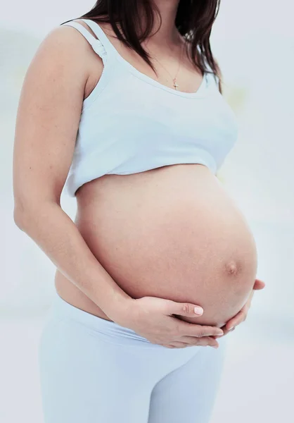 Woman holds her baby bump — Stock Photo, Image