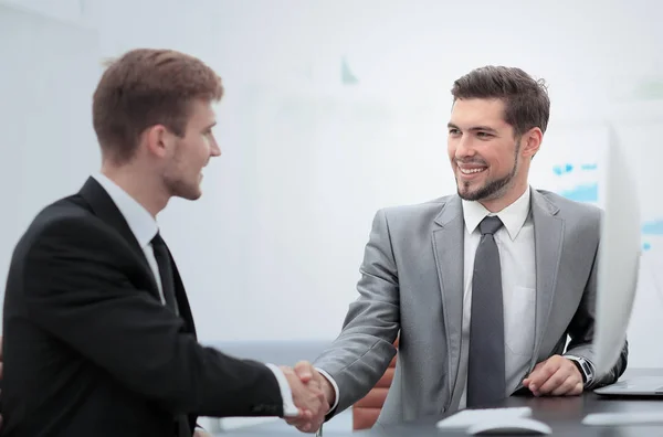 Happy business partners shaking hands in an office — Stock Photo, Image