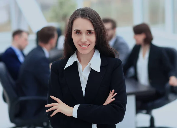 Exitosa mujer de negocios de pie con su personal en segundo plano en la oficina — Foto de Stock