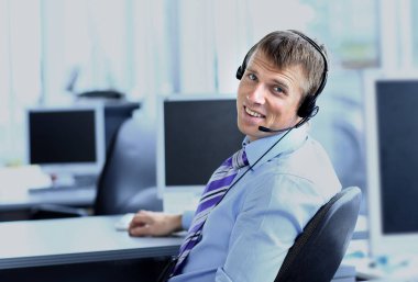 kulaklık kullanarak callcenter çalışma mutlu genç adam