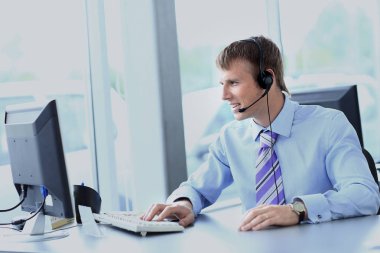 kulaklık kullanarak callcenter çalışma mutlu genç adam