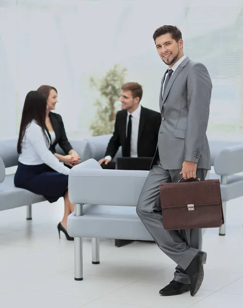 Uomo d'affari di successo in piedi con il suo personale in background a — Foto Stock
