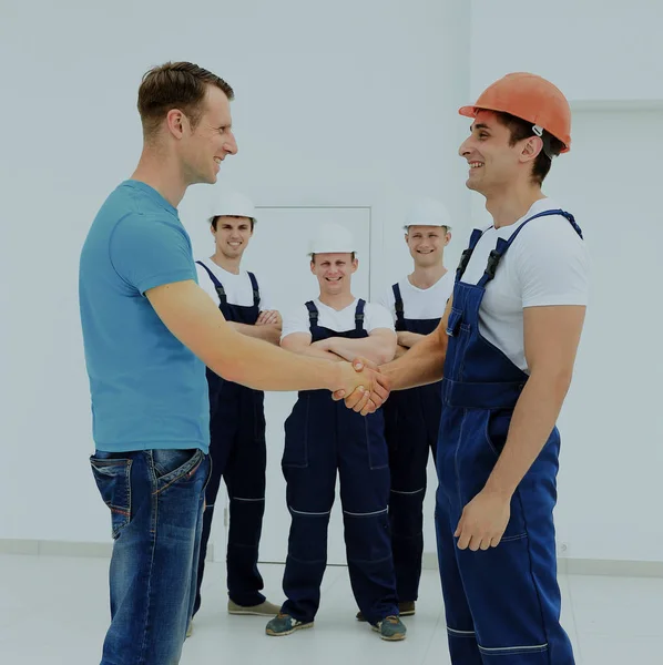 Клієнт тремтить руками з будівельником — стокове фото