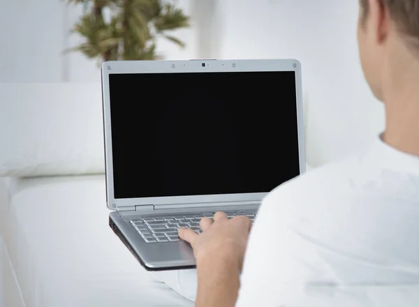 Rear view closeup of a young man working of a laptop — Stock Photo, Image