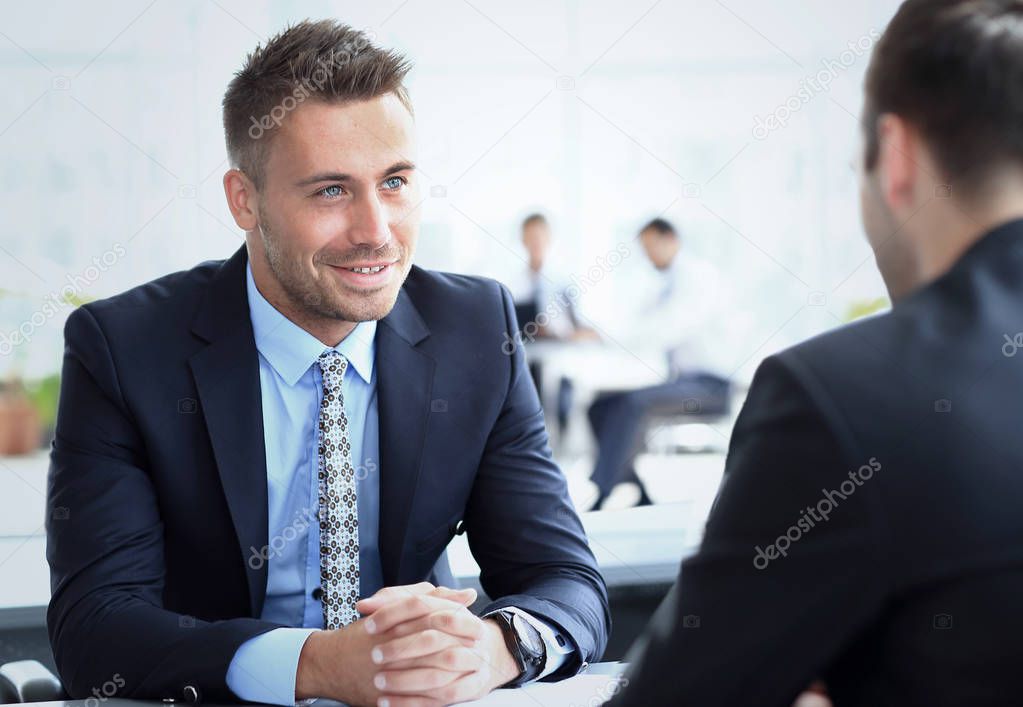 Image of smart businessman explaining new strategy to his partner at meeting