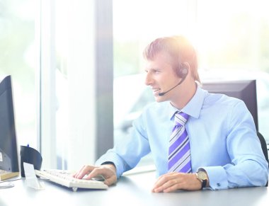 kulaklık kullanarak callcenter çalışma mutlu genç adam