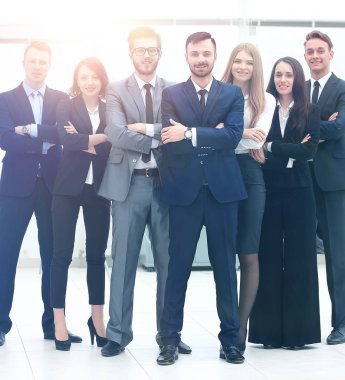 gülümseyen ve parlak bir pencerenin önünde emin iş takım ayakta