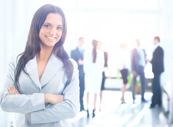 Erfolgreiche Geschäftsfrau steht mit ihren Mitarbeitern im Hintergrund im Büro — Stockfoto