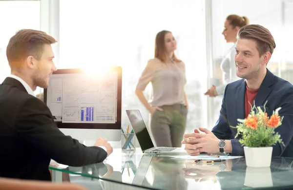 Business partners discussing in meeting hall with their collegue