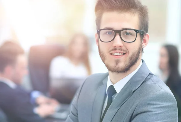 Retrato de um belo homem de negócios na frente de sua equipe — Fotografia de Stock