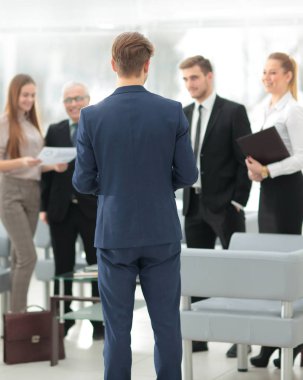 Başarılı iş adamı arka planda kendi personeli ile ayakta