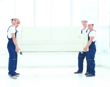 tek tip taşıyan mutlu erkek Nakliyeciler beyaz kanepe