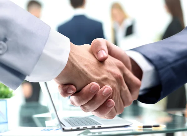 Nahaufnahme des Handschlags von Geschäftsleuten vor dem Hintergrund des Arbeitsplatzes — Stockfoto