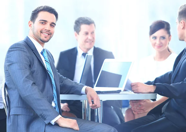 Portrait of mature business man smiling during meeting with colleagues in background — Stock Photo, Image