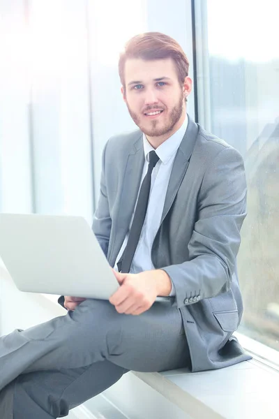 Przystojny biznesmen pracujący z laptopem w biurze — Zdjęcie stockowe