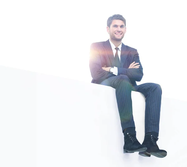 Junger Geschäftsmann sitzt auf einem weißen Top — Stockfoto