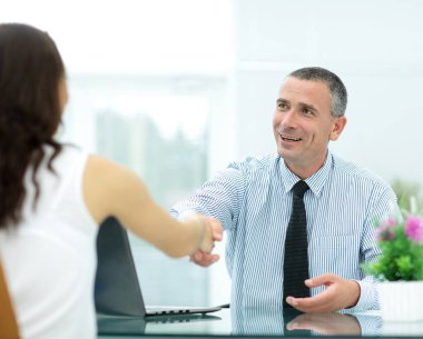 o toplantıda istemci ile el sıkışan başarılı iş adamı