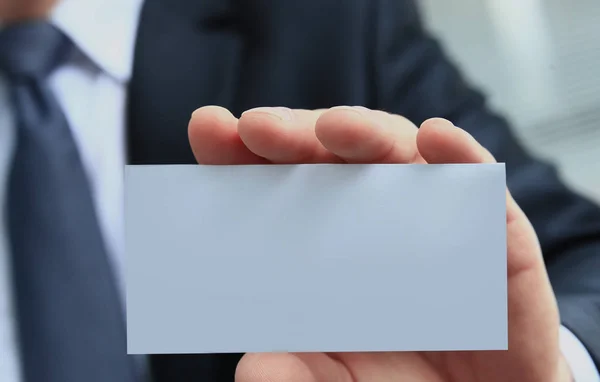 Mão estendida segurando um cartão de visita em branco — Fotografia de Stock