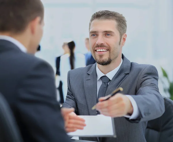 Geschäftsmann gibt einen Stift, um Deal mit seiner Partnerin zu besiegeln — Stockfoto