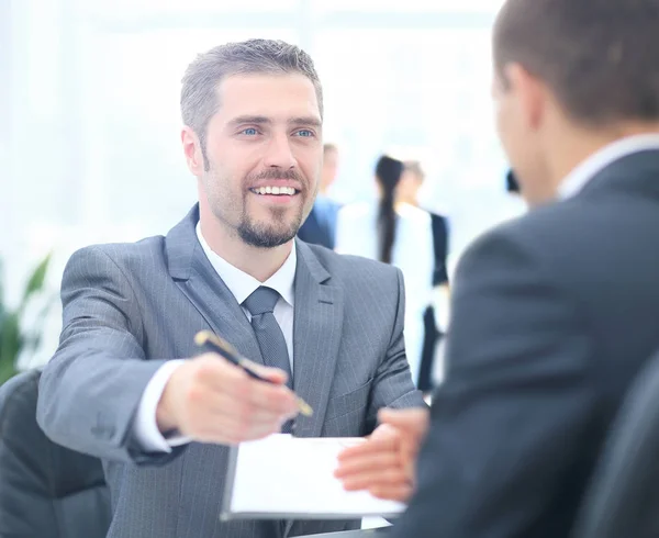 Geschäftsmann gibt einen Stift, um Deal mit seiner Partnerin zu besiegeln — Stockfoto