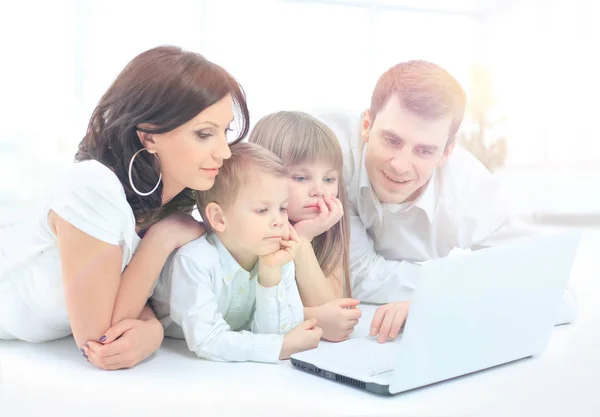 Rodzina szuka do laptopa entuzjastycznie — Zdjęcie stockowe