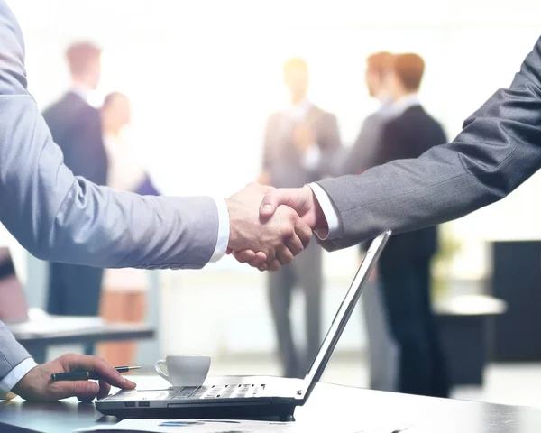 Selbstbewusster Händedruck. Nahaufnahme eines Handschlags. Geschäftsbüro in formeller Kleidung und Arbeit am Laptop — Stockfoto