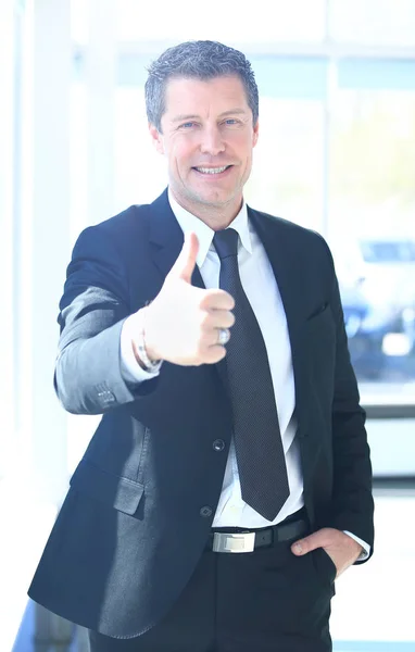 Businessman showing OK sign with his thumb up. Selective focus on face. — Stock Photo, Image