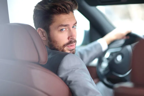 Portrait of an handsome smiling business man driving his car — Stock Photo, Image