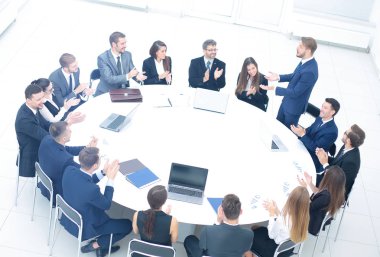 Finans Müdürü büyük bir yuvarlak masa ve sha söyler