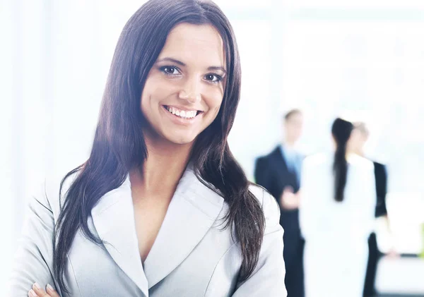 Geschäftsfrau steht mit ihren Mitarbeitern im Hintergrund im Büro — Stockfoto